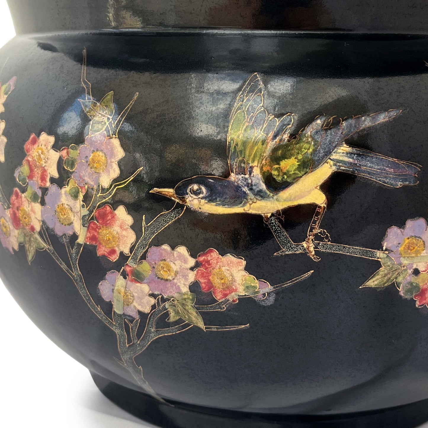 close up of large black jardiniere with bird and floral hand painted stem