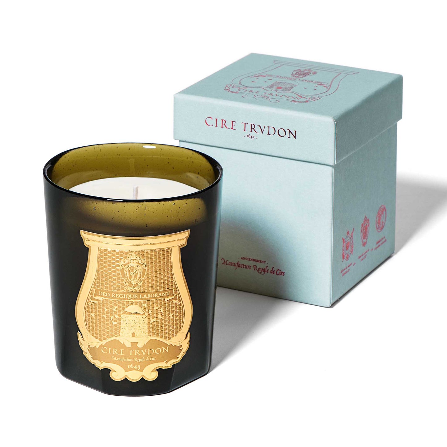 cire trudon candle in a green glass jar with a luxury gold label. this candle comes in a baby blue box with pink detailing