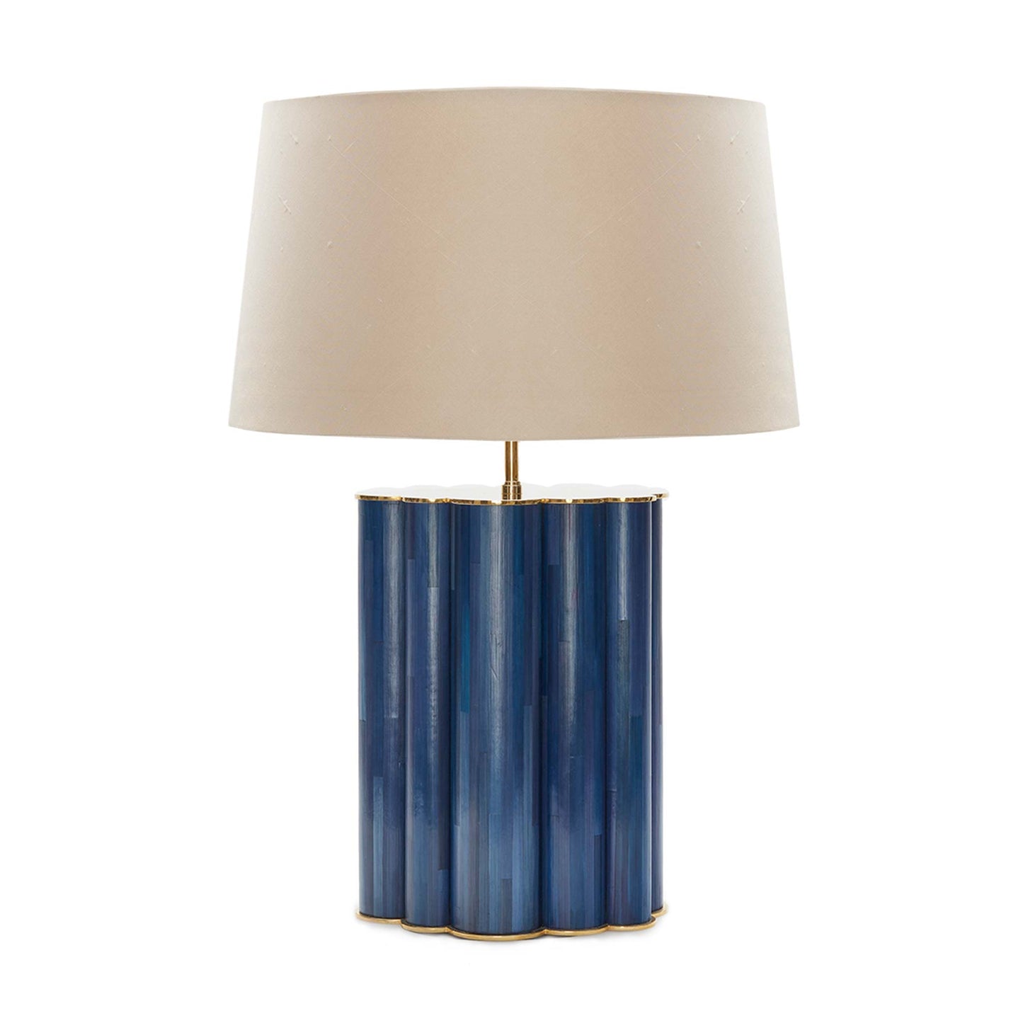 Table lamp with a brass top and base, encasing a deep blue cloud straw marquetry body in between. It is shown with a beige tapered linen lampshade