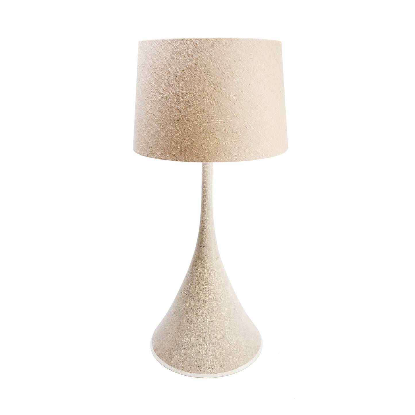 Cone shaped table lamp covered in a natural shagreen finish, completed with a thin layer of protective lacquer and a base of creamy white bone. the lamp is shown with a beige tapered linen lampshade