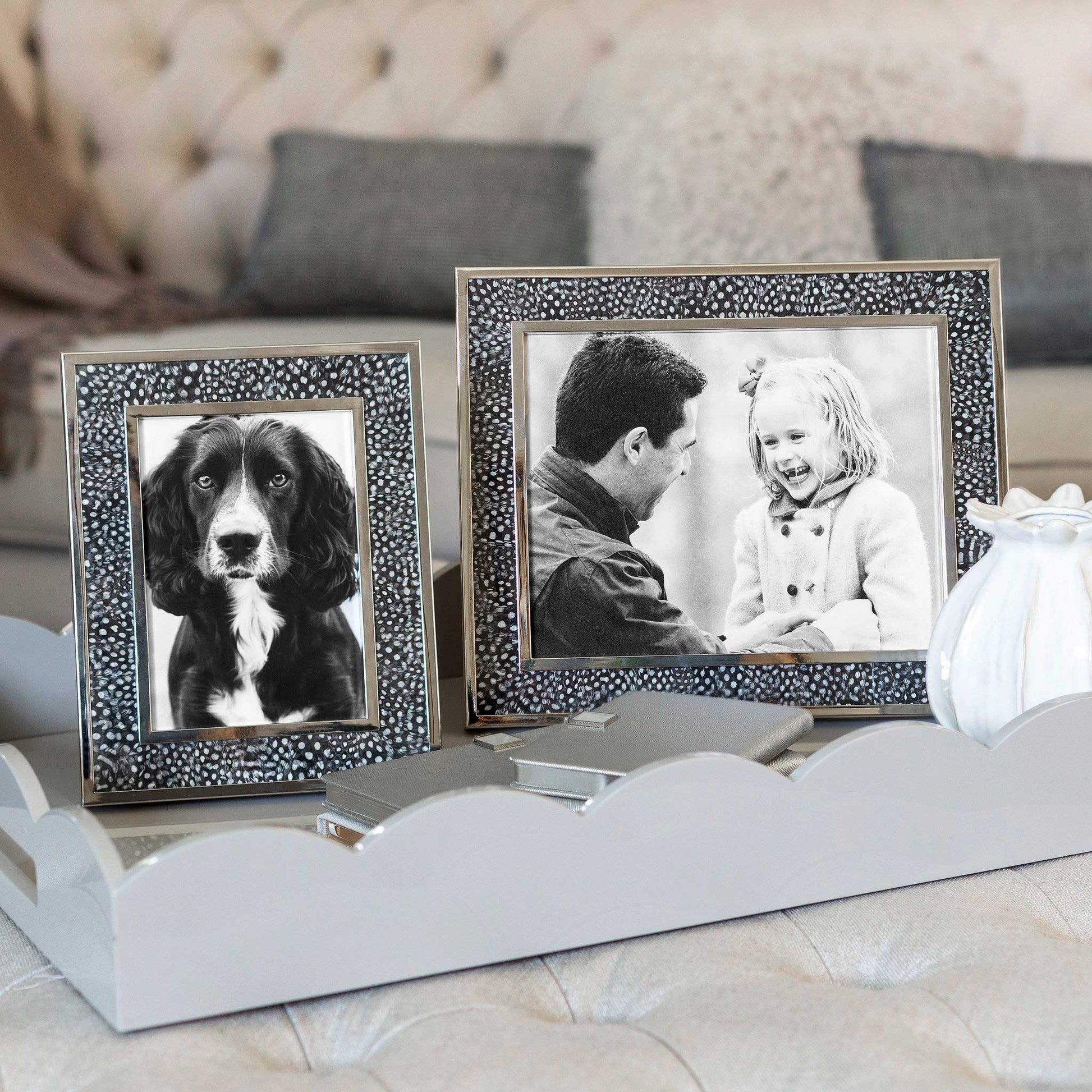 Lifestyle image of two spotty feather and silver photo frames