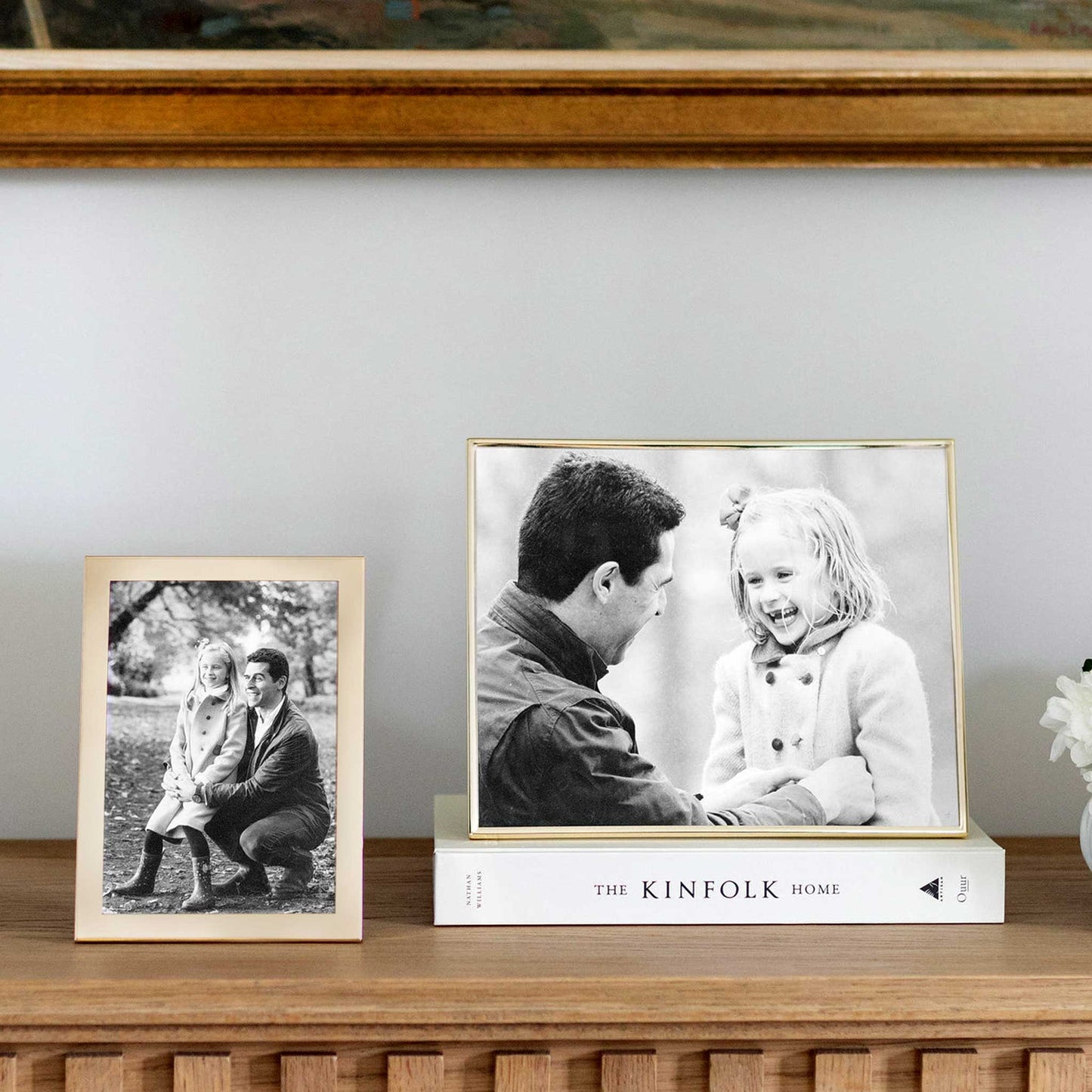 Lifestyle image of plain gloss gold photo frame on a console table