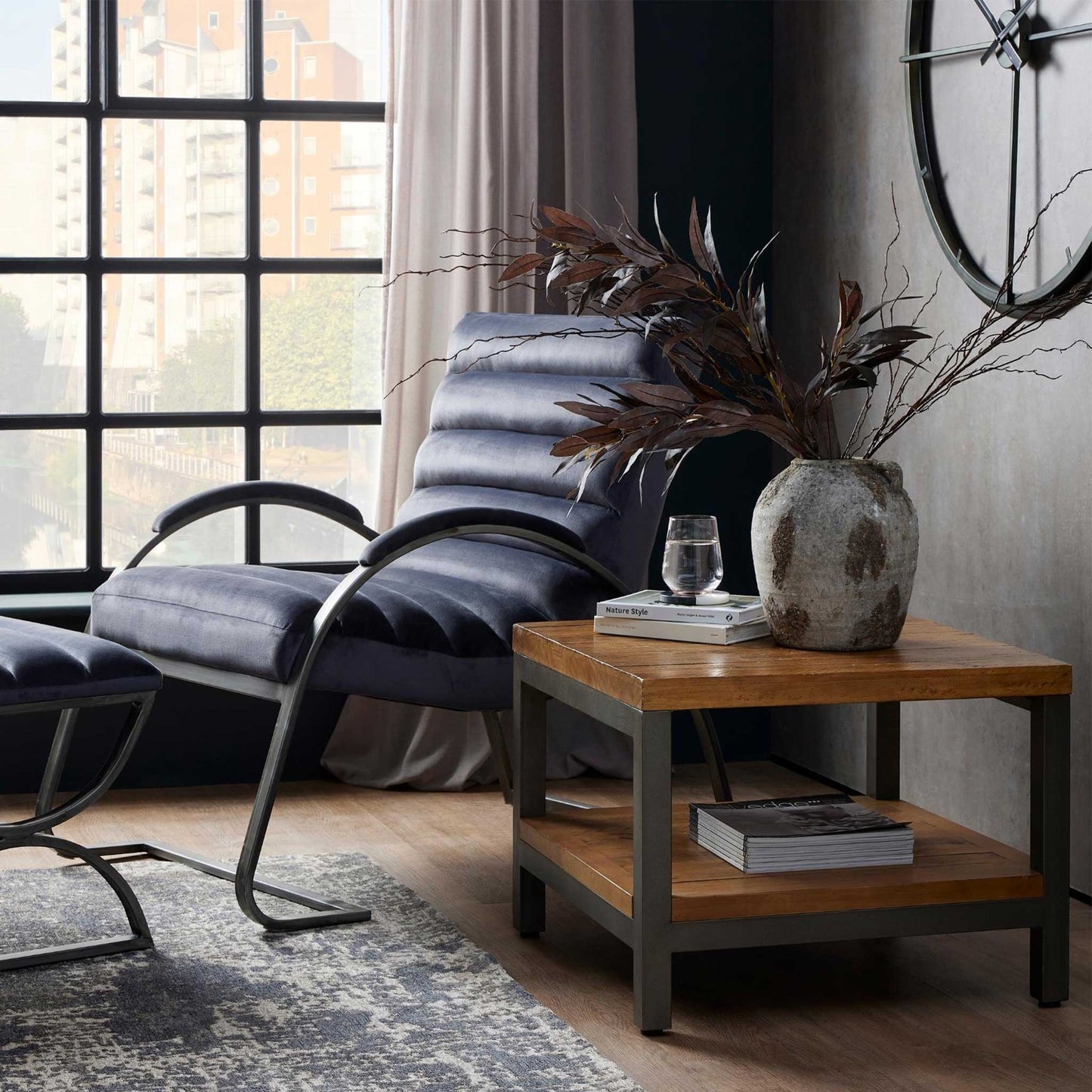 Lifestyle image of  jewel toned burgundy eucalyptus stems in vase and stylish living room.