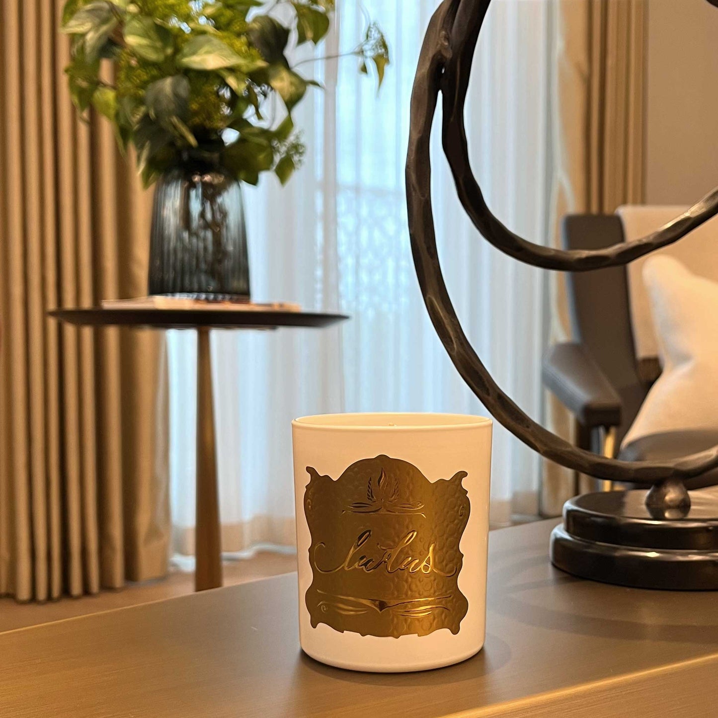 Lifestyle image of luxury Wild FIg scented candle. Shown in a white jar with a gold label. Displayed in a luxury living room.