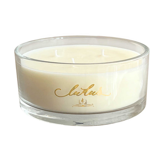 A three wick Oud candle in a wide glass jar.