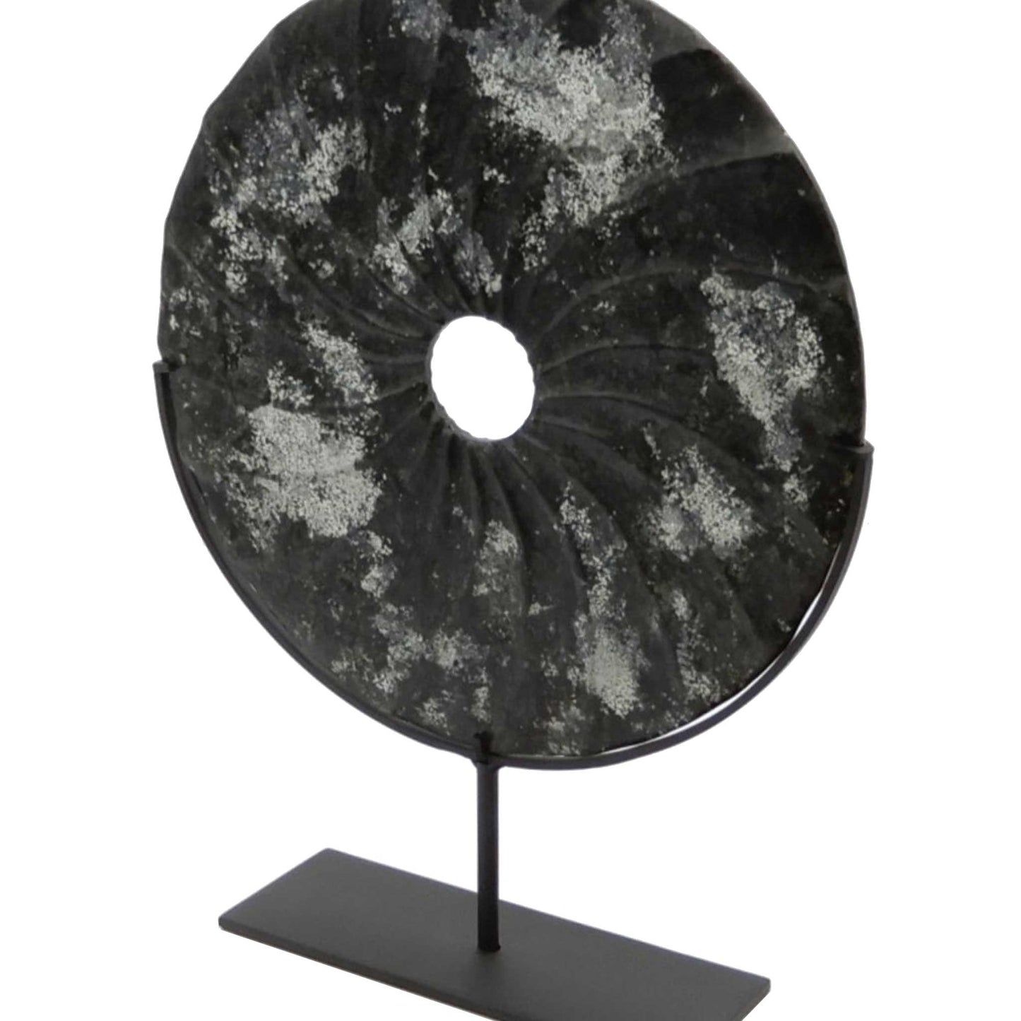 Distressed black marble bi disc with shell type grooves displayed on a bronze stand seen from a slight angle