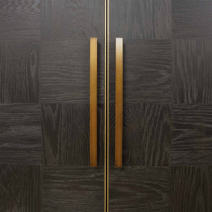 Close up of dark oak chessboard style wood panelled two door cabinet with brass details 