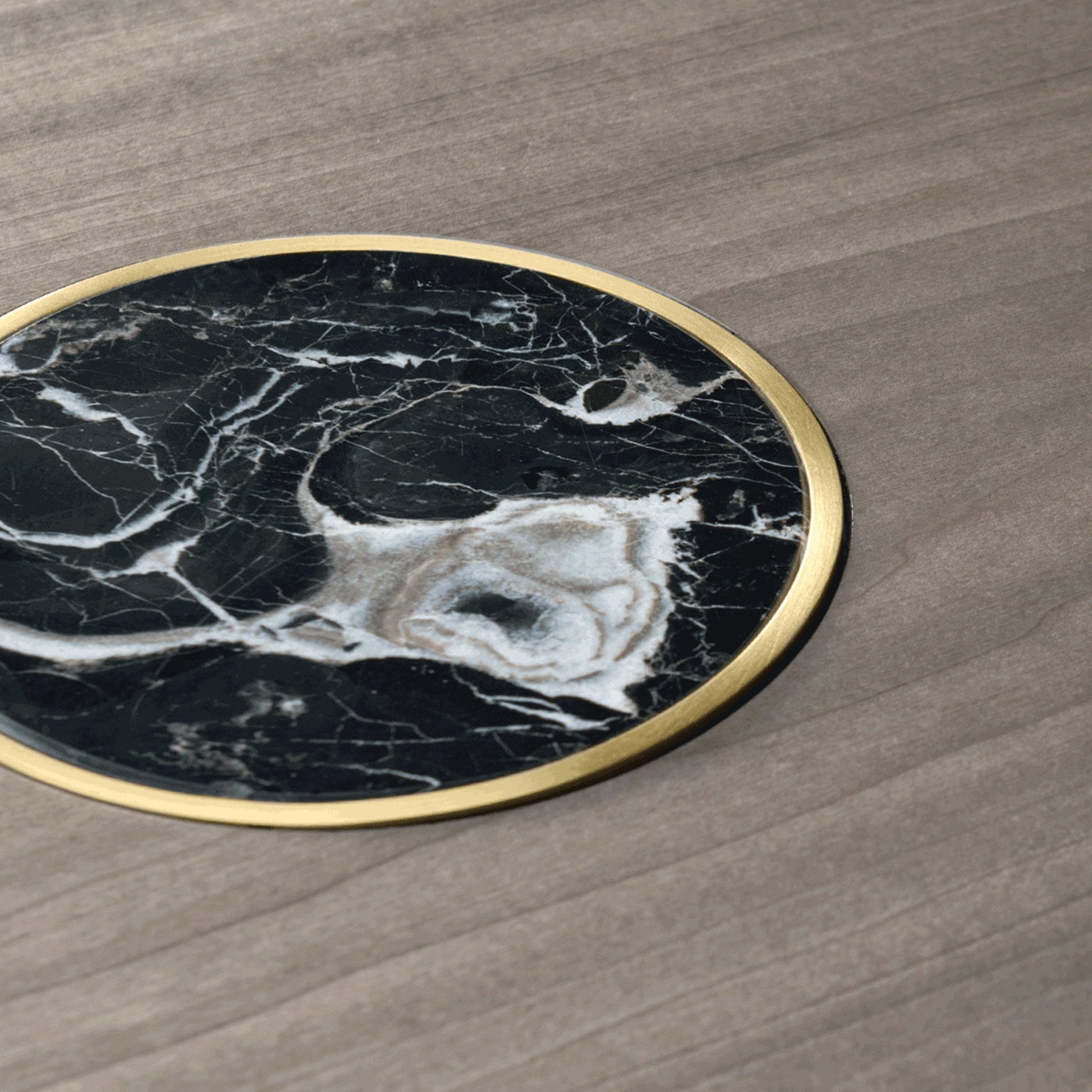 close up of the round table top showing the black marble inlay and brushed brass. detailing